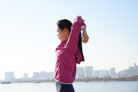 Young woman doing exercises at the seaside on fine day