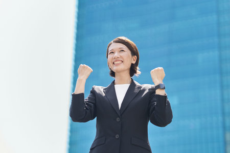 A woman in a suit posing for support on fine dayの写真素材