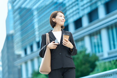 asian businesswoman smiling outdoors on fine dayの写真素材