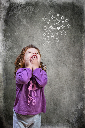 Joyful beautiful girl in night suit thinking at stars and heartsの写真素材