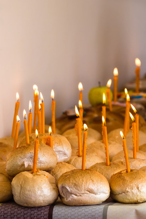 Breads with lighted candles for the living in memorial of dead people as part of commemoration ritual in orthodox religionの写真素材