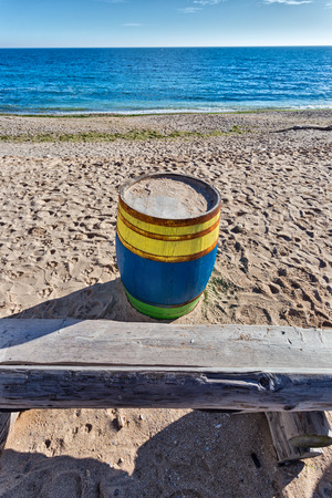 Black Sea  shore with a colored barrel and a massive wooden benchの写真素材