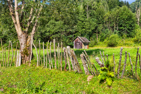 Mountain landscape with wooden shed and barbed wire fenceの写真素材