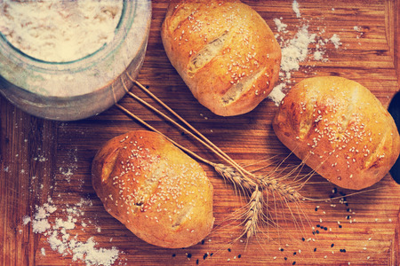 Mini homemade bread with sesame grains, just baked - retro filterの写真素材