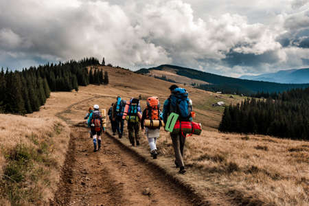 A group of tourists with backpacks moves along the ridge. Mountain trekking in the Ukrainian...