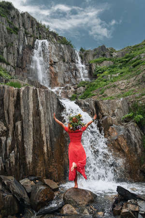 Young beautiful girl in the red dress with on the background of the Adishi glacier. Adish Glacier in Svaneti and the Caucasus Mountains.の写真素材