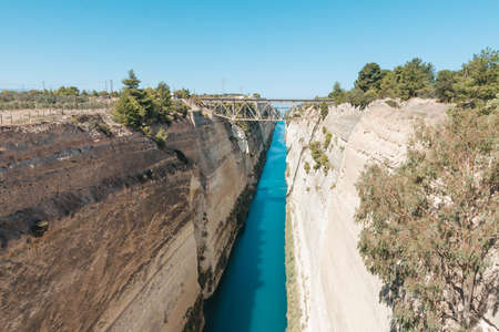 Seascape of both sides of Corinth's canal coast, left seaside glows in a golden sunrise light, right...