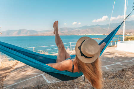 Beautiful girl relaxing in a hammock near the seaの写真素材
