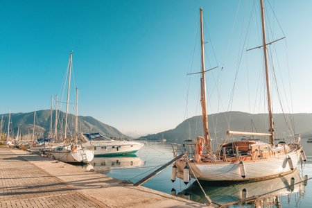 Summer sea view from coast with white yaht and mountains in background, Greece