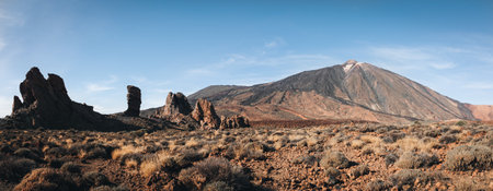 Panorama of caldera in Teide National Park, Tenerife, Canary Islands, Spain. Roques de Garcia in the foreground and snow covered mount Pico del Teide in the background.の写真素材