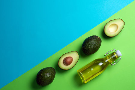 Fresh avocados on a blue and green background. Avocado oil in a bottle. Healthy Eating.の写真素材