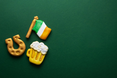 Banner for St. Patrick's Day on green background. Coins, horseshoes, Ireland flag as symbols of the holiday. Place for text. Gingerbread cookie items.の写真素材