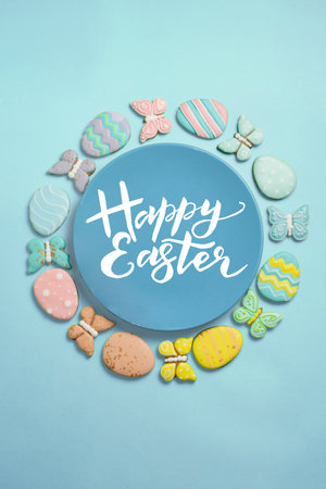 Easter banner on a blue background. Homemade gingerbread cookies on a blue plate, Easter eggs and...