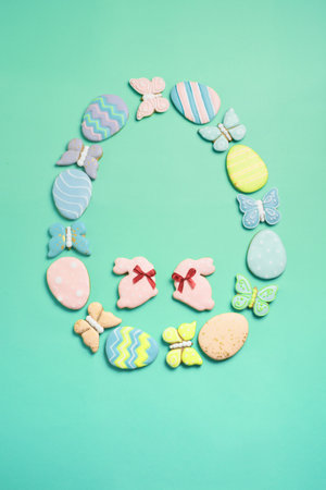 Easter banner on a mint background. Homemade gingerbread cookies. Easter eggs and cookies in the shape of a rabbit and a butterfly. Easter concept.の写真素材