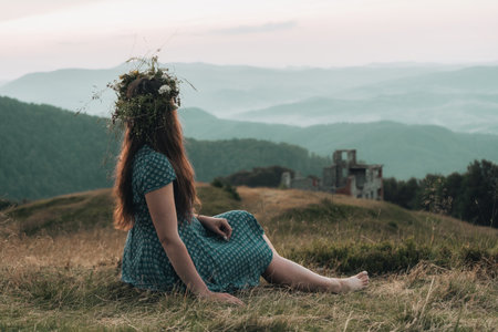 A girl in a wreath of flowers enjoys the sunset in the mountains. Beauty Girl Outdoor. Freedom concept.の写真素材