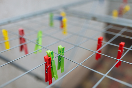 Multicolored: red, yellow, green, blue clothespins on the rack,background image ,text betting/ dryer...