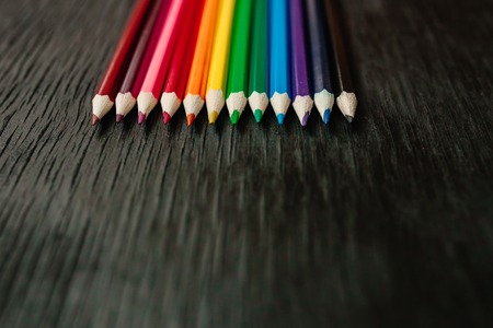 Many colored pencils on a black background. New pencils. Isolated background to insert textの写真素材