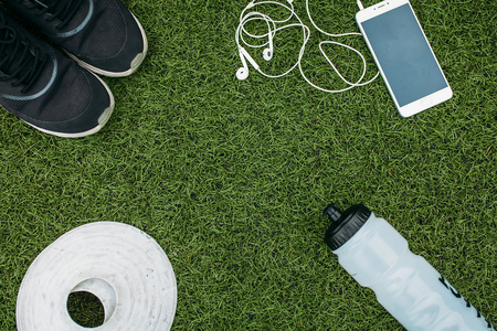 Sports set boy or girl, who likes to run. Phone, headphones, shoes, water bottle and chips for running. Isolated place for textの写真素材