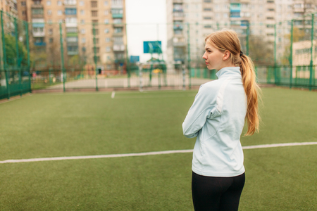 A young girl goes in for sports, portrait, handsome Girl in sportswear. The Girl works in the open, fresh air. Isolated place for textの写真素材
