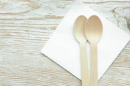 Two wooden spoons lying on a napkin in a cafe on wooden table, isolatedの写真素材