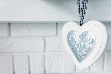 Beautiful white heart, hanging on a decorative background for Valentine's day, isolatedの写真素材