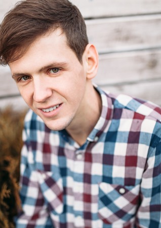 Portrait of man closeup of handsome guy smiling, the man in the checkered shirt on, on the...