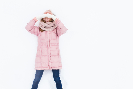 Young positive girl on white isolated background, snow field, winter morning, happy beautiful, the picture for the ad, insert textの写真素材