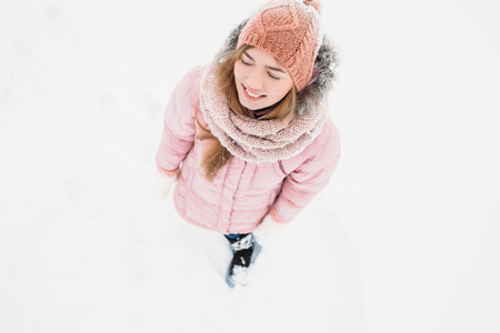 Girl posing outdoors, a woman looks up smiling and happy young woman in ski clothes outdoor recreation in cold weather ,image for advertising,insert textの写真素材