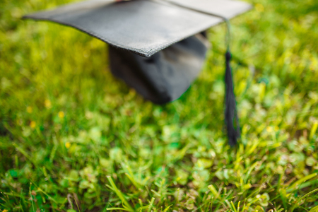 Cap graduate, lying on the lawn, green grass, can be used for advertising,の写真素材
