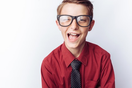 Portrait of a positive teenager on a white background, glasses, red shirt, advertising,の写真素材