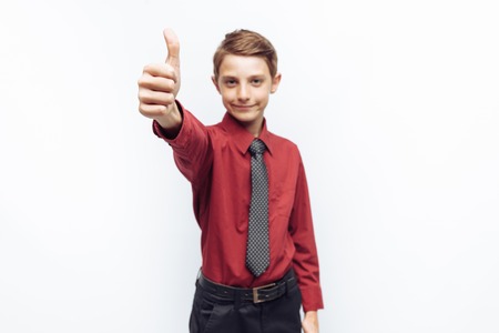 Portrait of a positive teenager on a white background, and shows class, in red shirt, advertising,