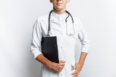 Young and handsome doctor, Intern student with folder in hand, white background,の写真素材