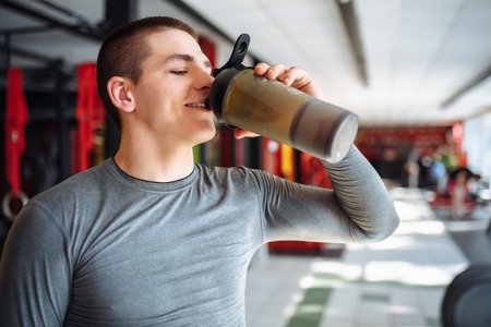 Man athlete took a break in training and drinking water