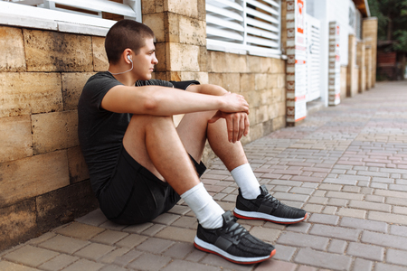 Athlete man posing against the wall, morning jogの写真素材