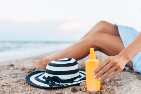 girl resting on the beach, beautiful tanned legs against the blue seaの写真素材