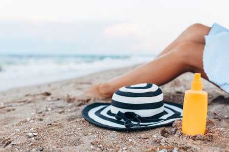 girl resting on the beach, beautiful tanned legs against the blue seaの写真素材