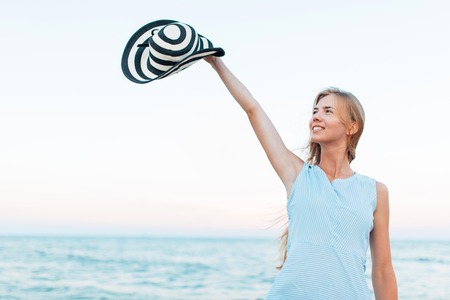 The girl was resting his hands up on the background of blue sky, concept of freedomの写真素材