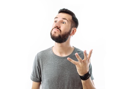 close-up portrait of a young man with a beard, wearing a gray t-shirt , with an irritated...