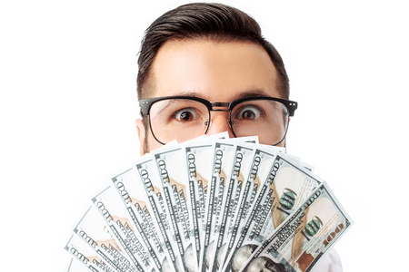 Image of an excited hipster young man standing isolated on a white background holding money. Looking at the cameraの写真素材