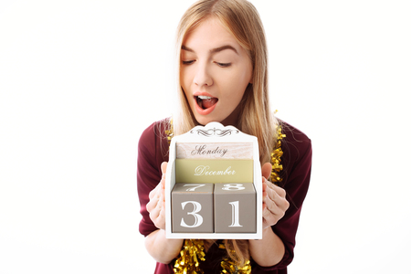 Surprised beautiful woman, with a calendar from December 31 in hands, on a white background. Christmasの写真素材
