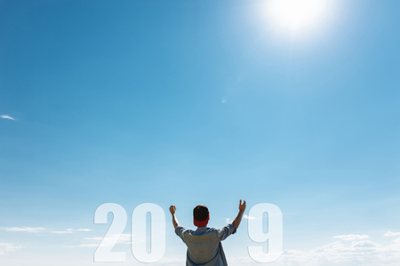 Man, against the blue sky, the guy pulls hands to the sky, the concept of the new 2019 year....