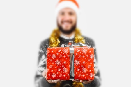 A man with a Christmas gift in his hands, in the Studio on a white background, gift close-up