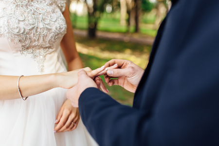 the bride and groom wear rings, rings close-upの写真素材