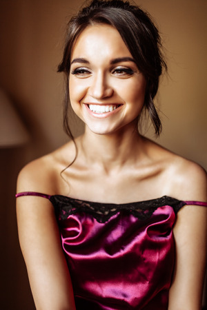 Portrait of a beautiful girl with makeup and evening hair, in the roomの写真素材