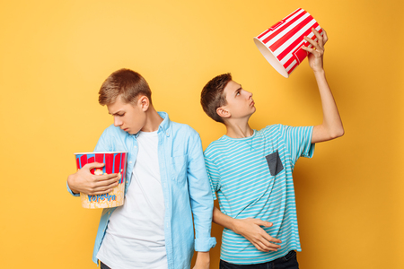 Two teenagers eating popcorn and having funの写真素材