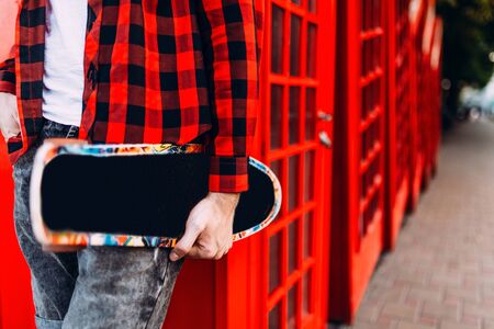 A man holds a skateboard in his hands, a walk in the parkの写真素材