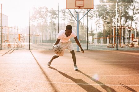 Strong handsome young African sports people in the stadium in the open air to play basketball.