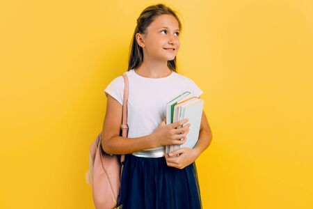 A teenager in school clothes with a backpack and books. Purposeful and diligent. Stylish beautiful...