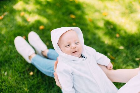 Mother and newborn baby. A mother holds her young son in her arms while walking in the Park in Sunny weather. Mother's dayの写真素材