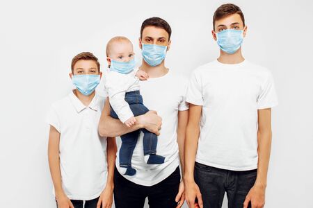 CAVID-19 pandemic coronavirus a young family, parents and children wear a protective mask to protect against viruses, coronavirus disease, on an isolated white backgroundの写真素材